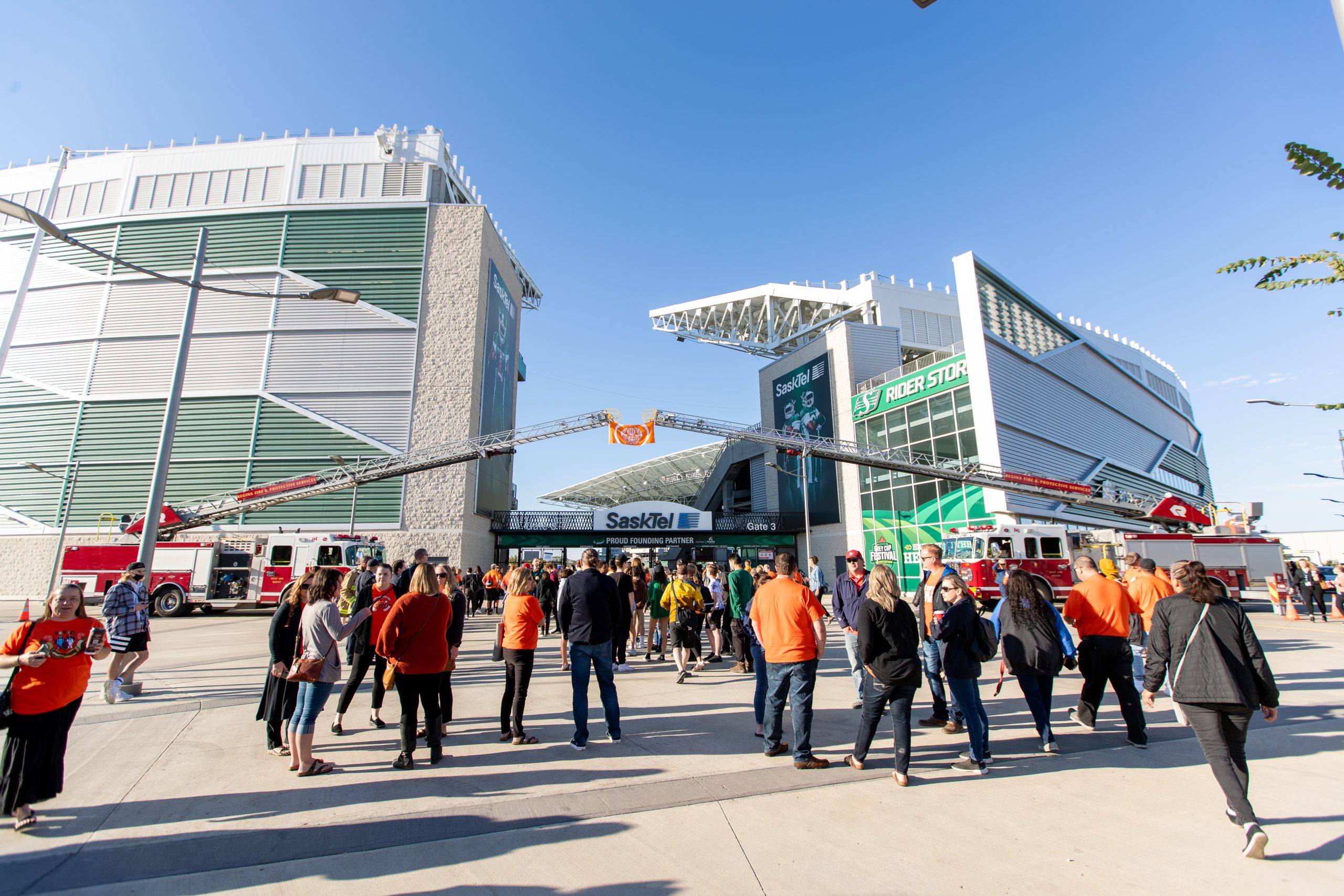 People outside stadium with fire trucks on standby.