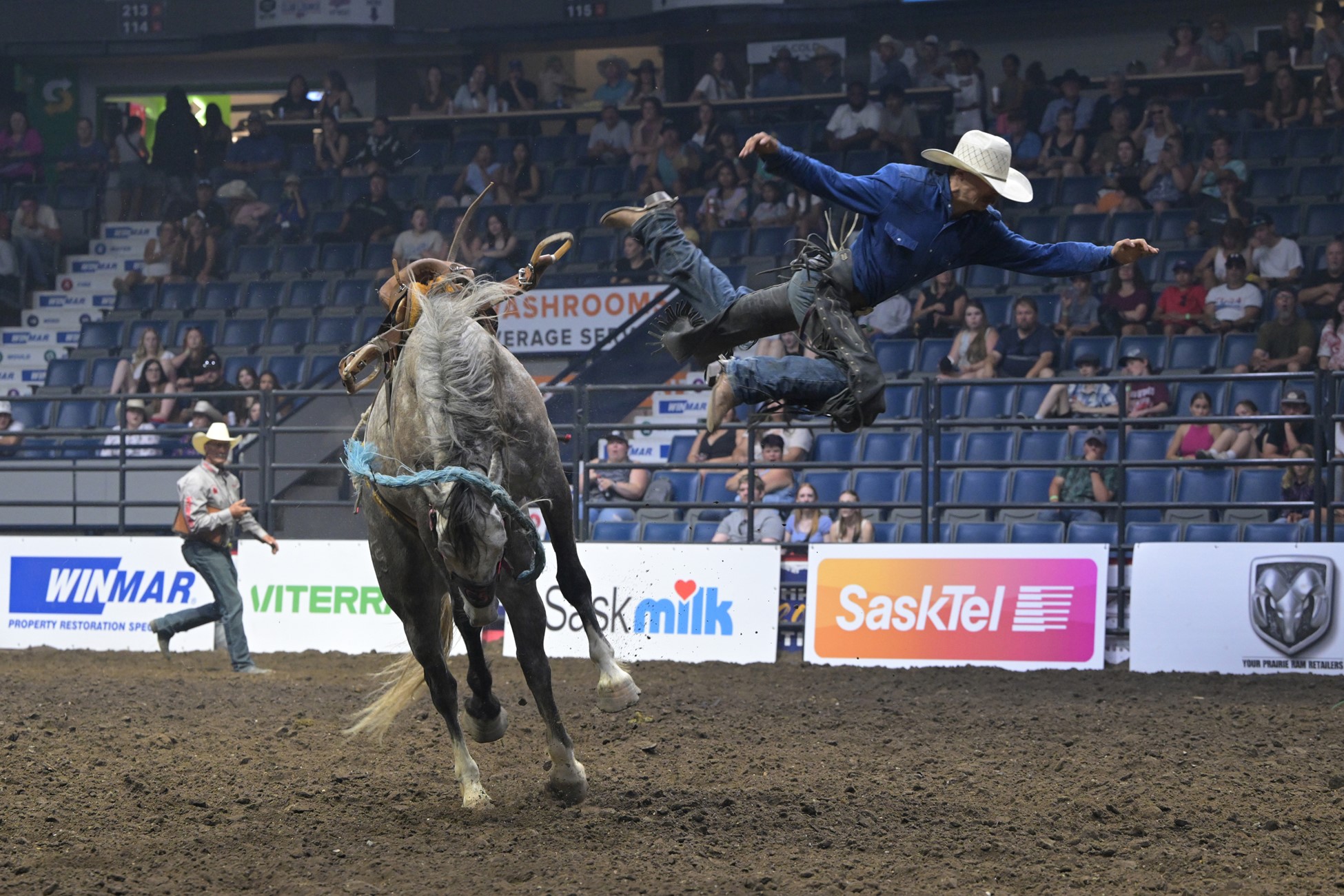 Rodeo rider in midair after bucking bronco.